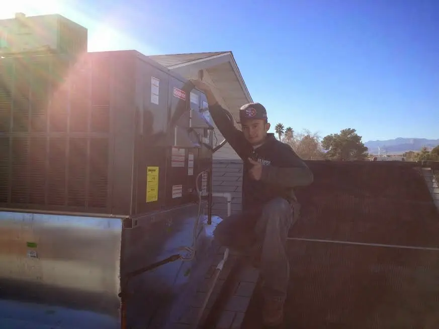 HVAC technician performing Air Duct Cleaning on a rooftop unit in New Garden